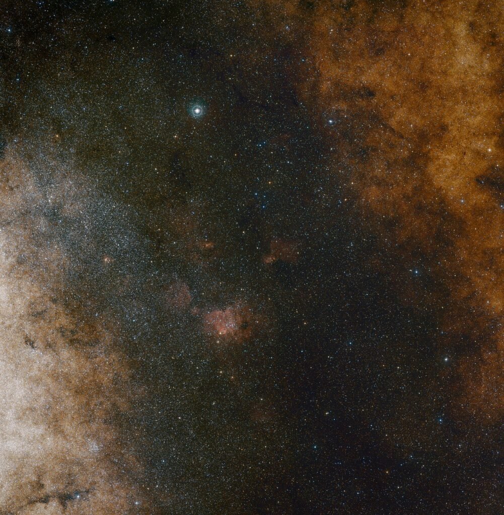 Ảnh góc rộng chụp vùng trung tâm Ngân Hà qua ánh sáng quang học. Trong ảnh, bạn có thể dễ dàng thấy được đám mây sao phong phú ở chòm sao Sagittarius. Thực tế, còn rất nhiều sao nhưng chúng bị che đi bởi các đám mây bụi, ta chỉ thấy được chúng khi quan sát qua ánh sáng hồng ngoại. Ảnh: ESO and Digitized Sky Survey 2.